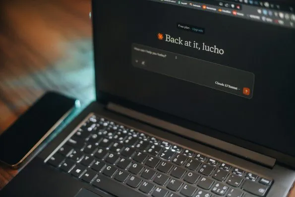 Laptop screen says "back at it, lucho". Laptop screen says "back at it, lucho".